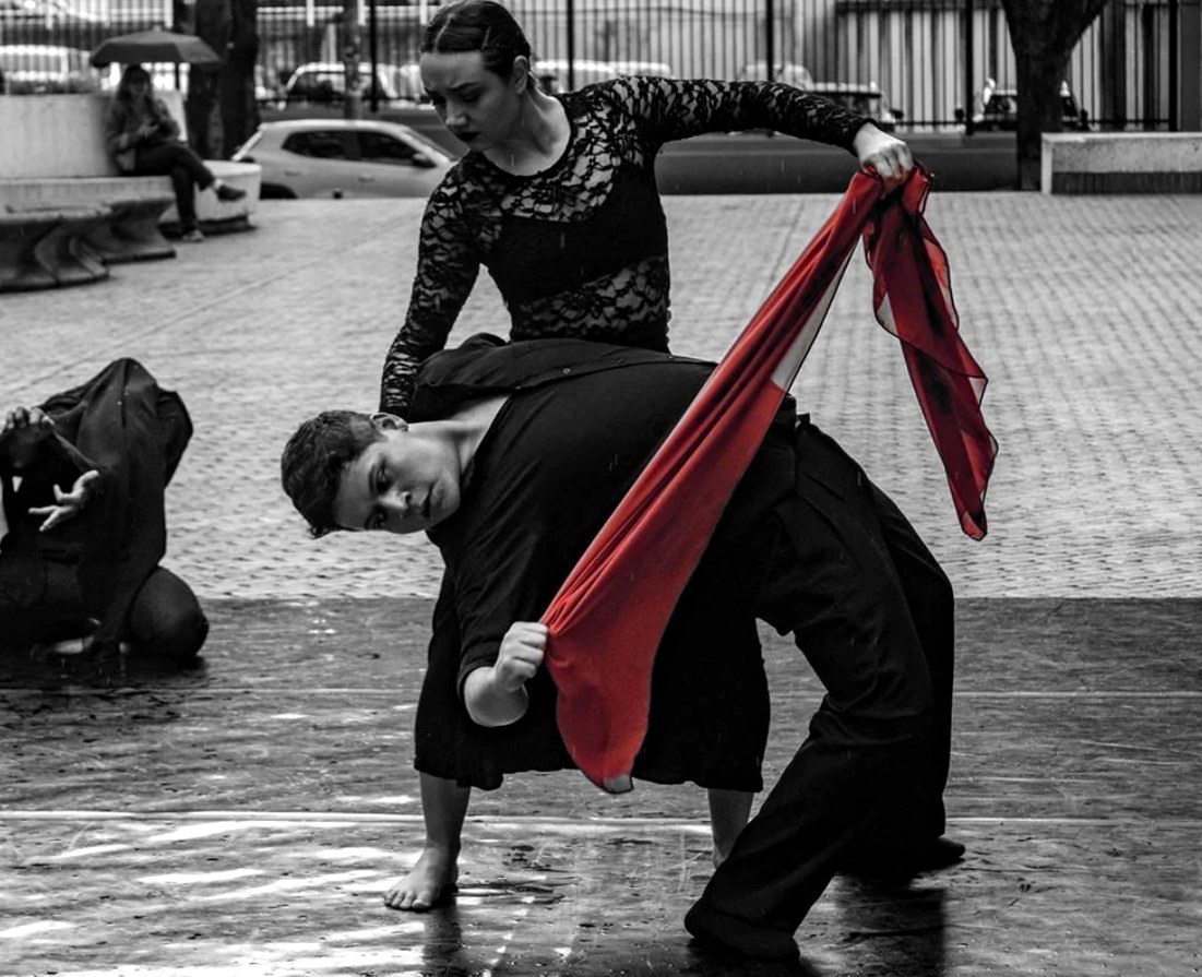 Bailarines del FUDC en escena con una tela roja